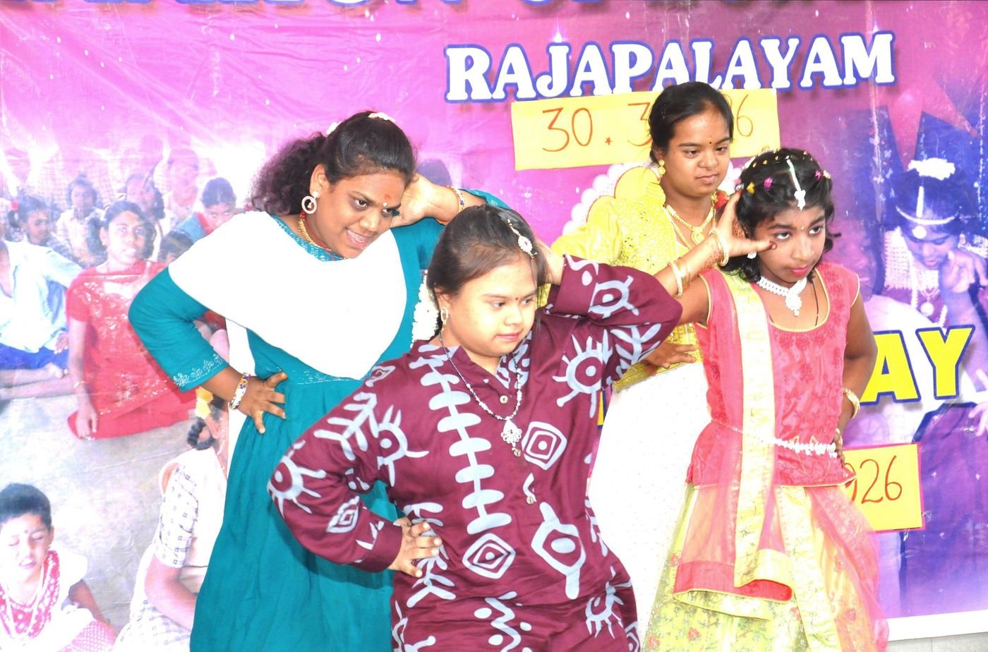 Three students in colourful dress perform a dance on stage at Annual Day